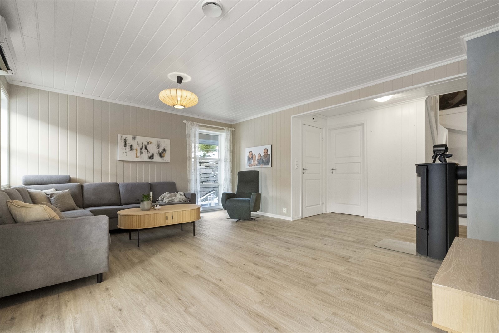 Stova er lys og usjenert. Her er det både varmepumpe og vedomn. Galleribilde