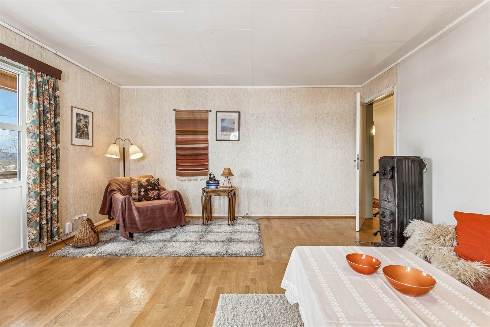 En vedovn fra byggeåret gir en ekstra varmekilde i stuen. Galleribilde