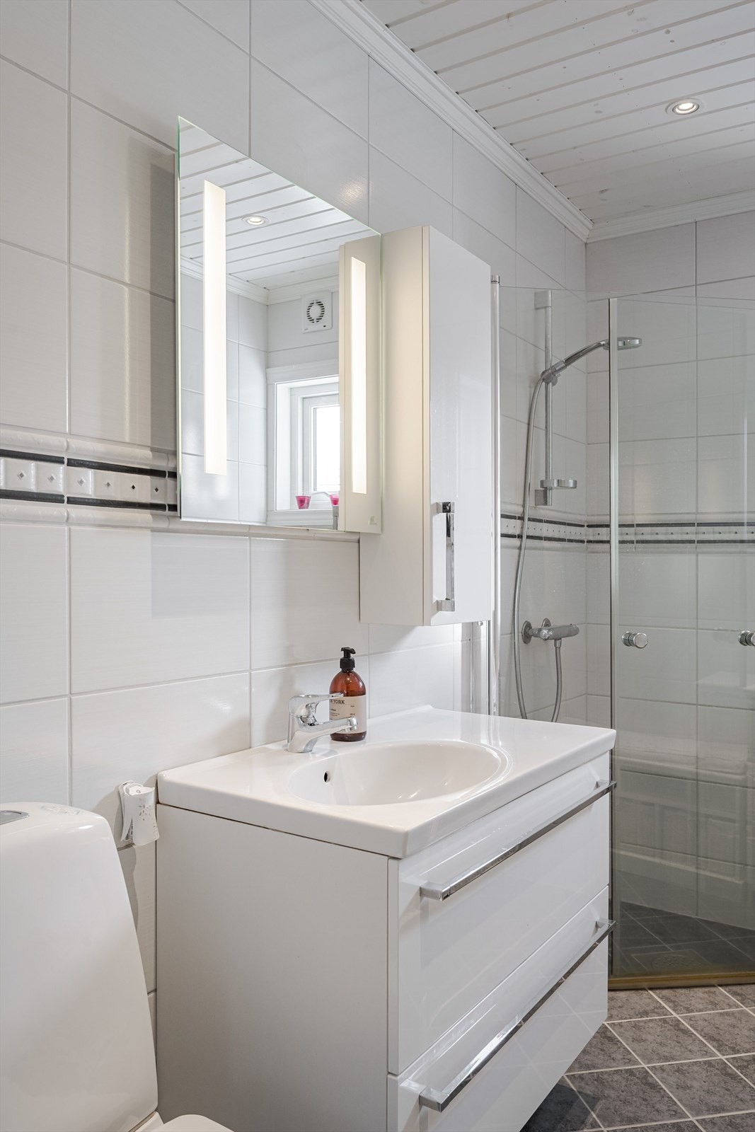 Innredning med skuffer, heldekkende servant og speil med integrert lys. Elektrisk styrt ventilasjon. Galleribilde