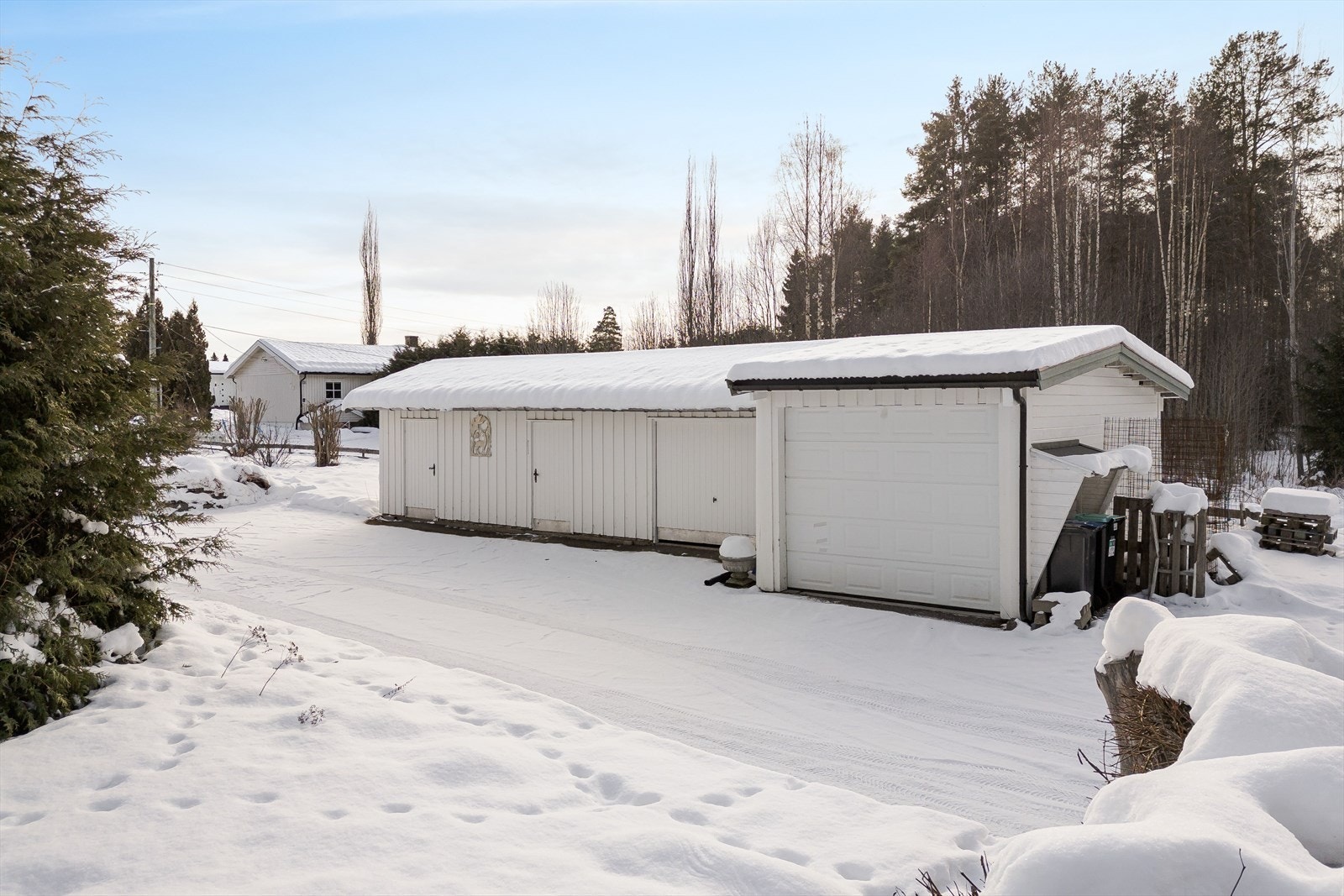 Frittstående garasje med to foldeporter av nyere dato. Galleribilde