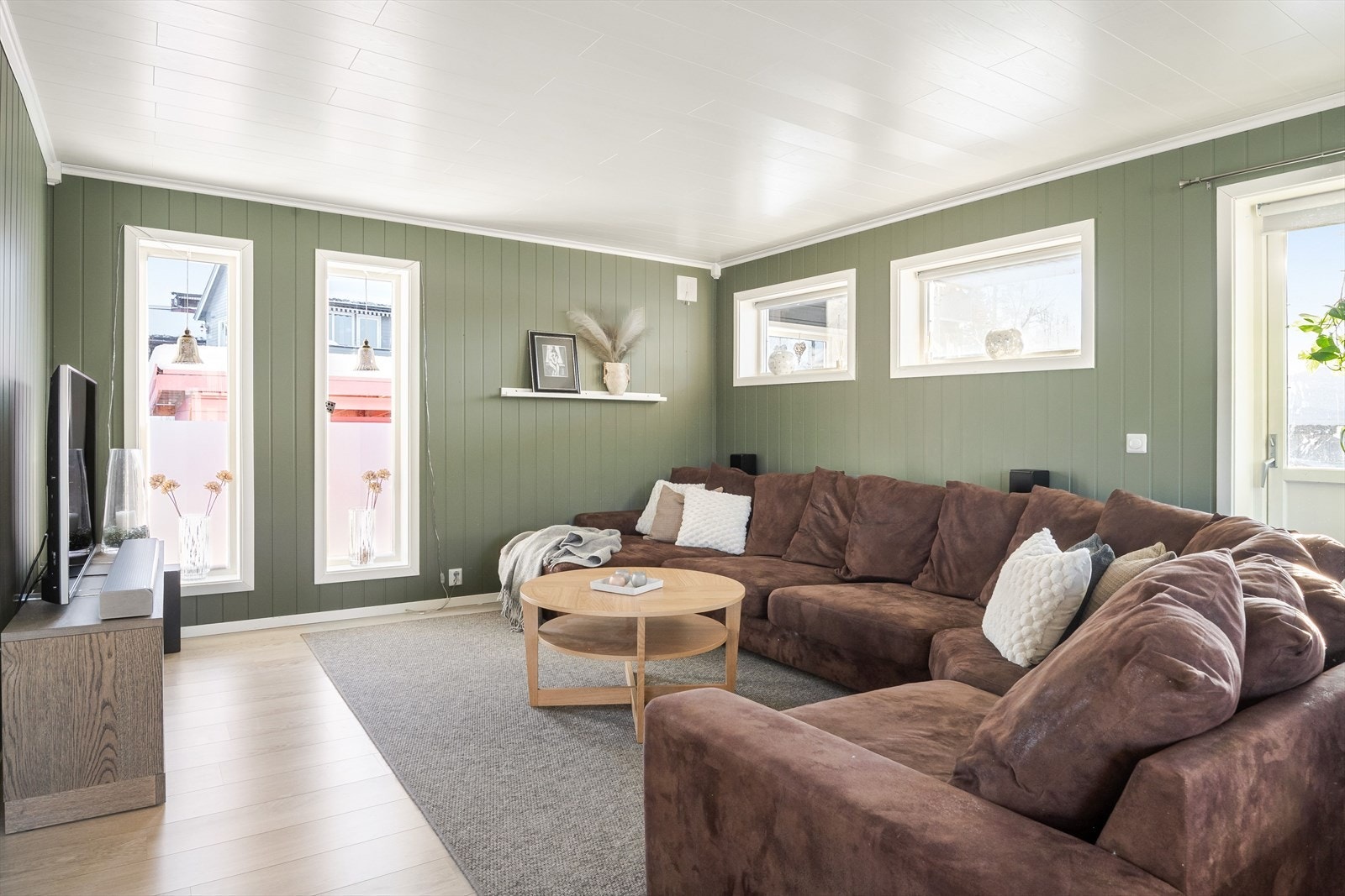 Stuen er malt i delikate farger og har god plass til stor sofagruppe. Galleribilde