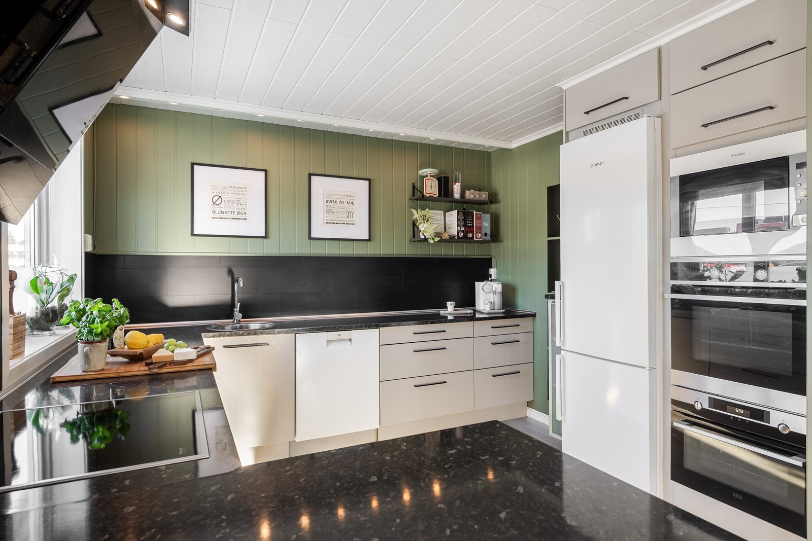 Kjøkkeninnredning med laminert benkeplate, glatte fronter, skuffer og kitchenboard over kjøkkenbenk. Galleribilde