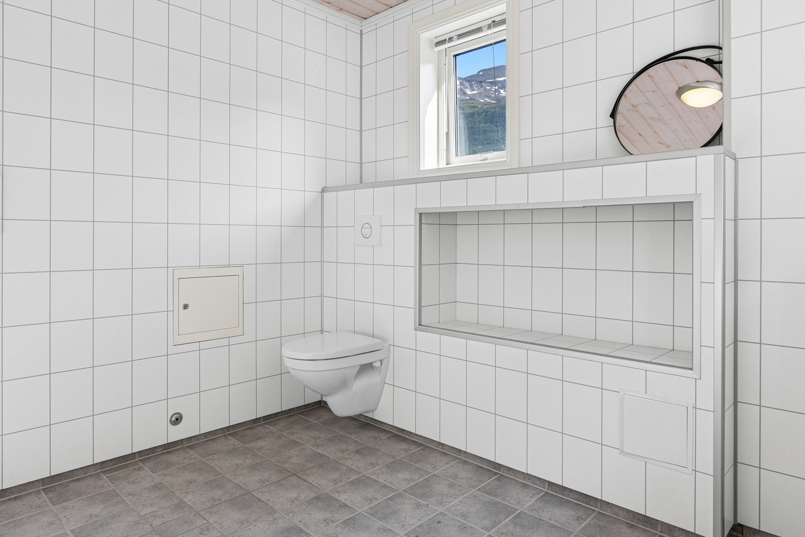 Det er bygget inn praktisk nisjehylle i veggen ved toalettet som gir plass til ekstra oppbevaring på badet. Galleribilde