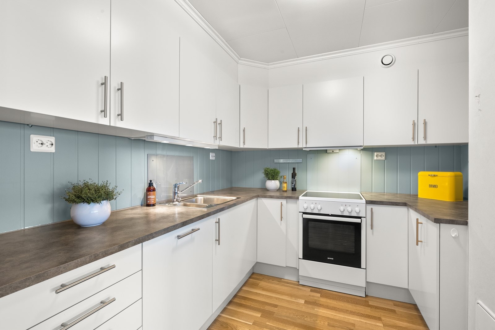 Kjøkkenet er utstyrt med en moderne innredning med glatte fronter og en slitesterk benkeplate i laminat. Galleribilde