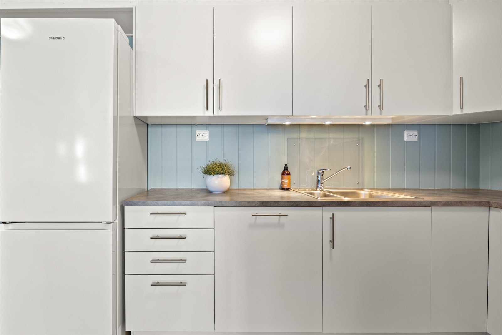 Det er montert backsplash bak komfyr og vask. Galleribilde