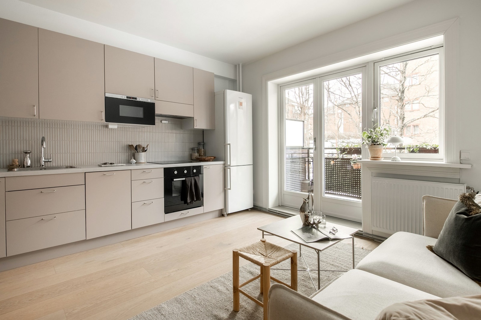 Praktisk kjøkken med glatte stilrene farger og gode materialer. Godt med skap- og benkeplass. Galleribilde