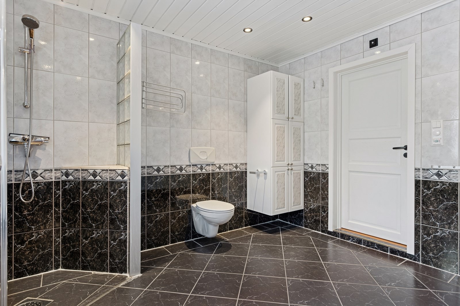 Badet har flislagte overflater og god størrelse, men det er registrert noe normal slitasje og enkelte forhold som bør utbedres over tid, blant annet småsår, stedvis bom i flis og løse fliser rundt vinduskarmen. Det er tilnærmet flatt fall på gulvet. Galleribilde