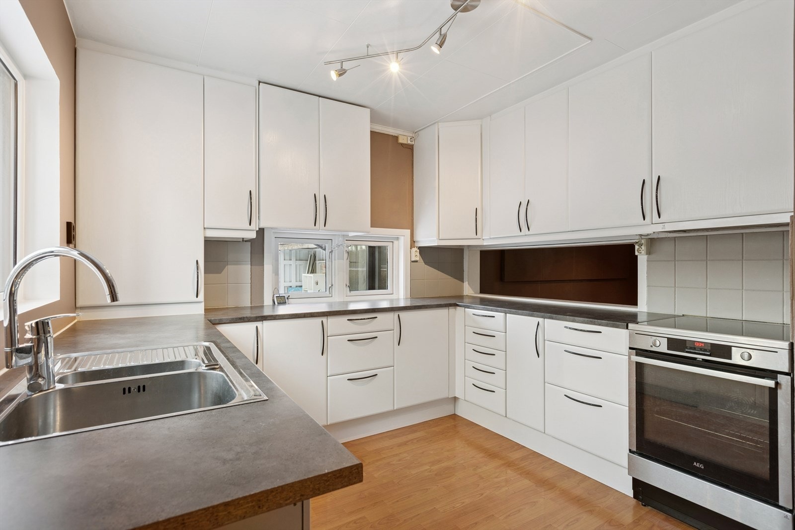 Kjøkkenet ligger tilbaketrukket men likevel åpen løsning mot spisestue og stue. En praktisk serveringsluke mellom kjøkken og stue skaper en funksjonell og sosial planløsning. Galleribilde