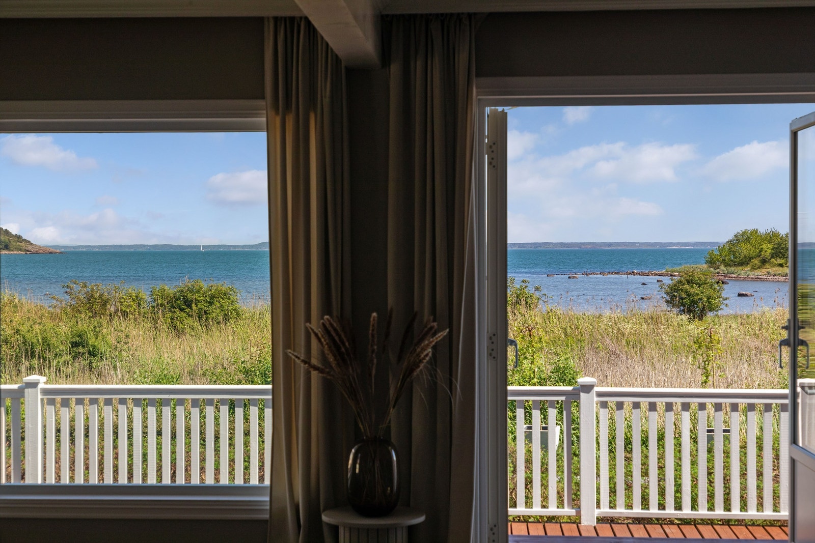 En sjøvendt utsiktsbalkong på ca. 11 kvm med utgang fra hovedsoverommet, en deilig, overbygd uteplass forlange sommermorgener i solen. Galleribilde