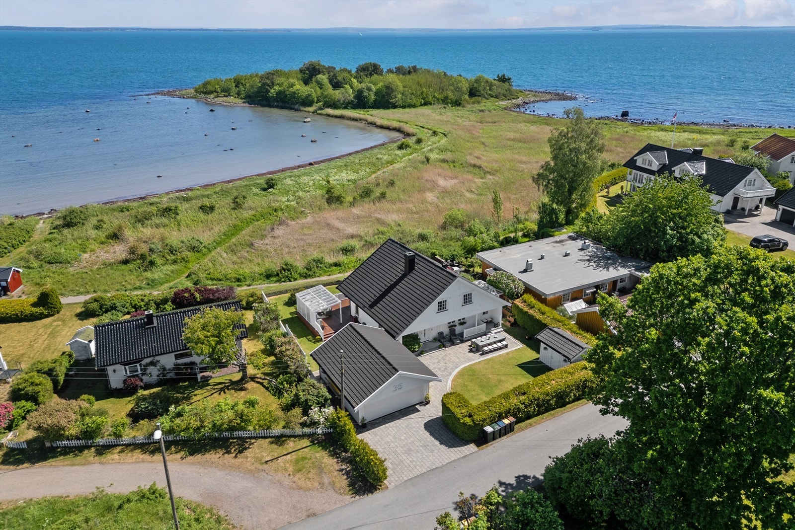 Gårdsplassen er steinsatt og strekker seg over i en markterrasse foran inngangspartiet i sydvest, hvor den er pent kantet med stein mot plenarealene. Galleribilde