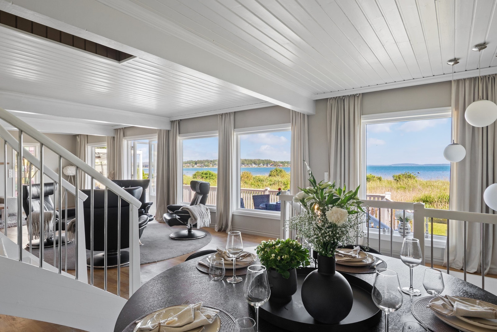 Fra stuen fører en hvitmalt trapp med stålspiler og åpne trinn opp til andre etasje, samt en tilsvarende trapp ned til kjellerstuen. Galleribilde