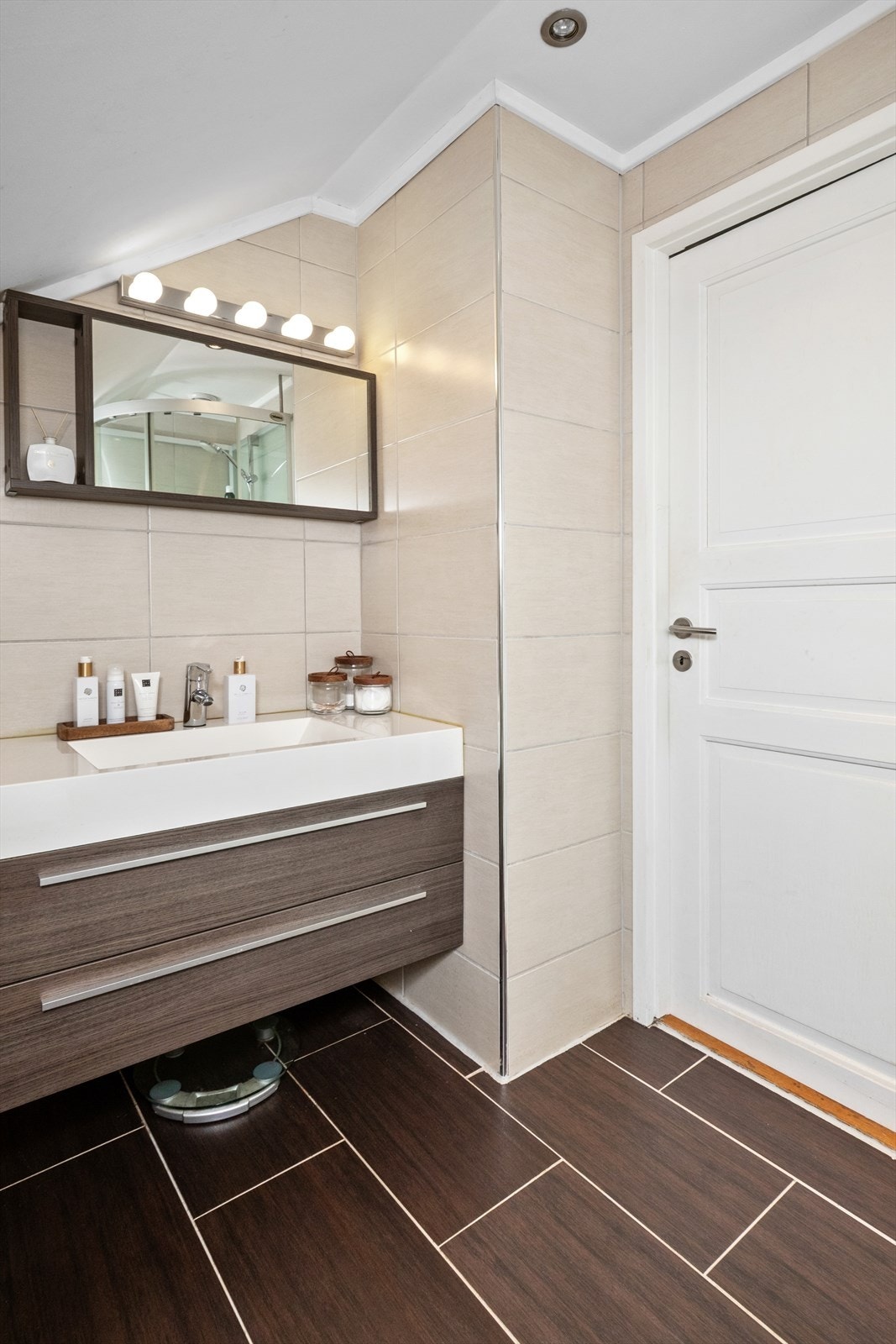 Badet i loftsetasjen ble oppgradert i 2010 og fremstår som delikat med beige veggfliser, brune gulvfliser, gulvvarme og hvitmalt himling med downlights. Galleribilde