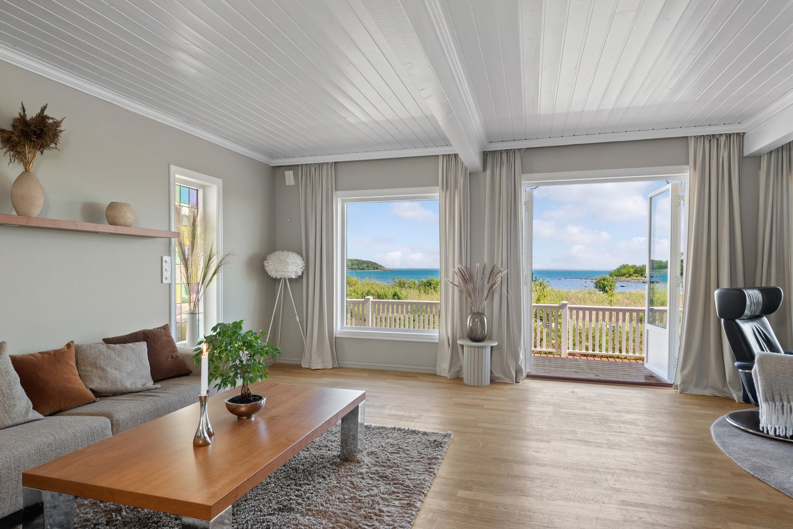 Stuen er lys og trivelig med store vindusflater og tofløyede terrassedører som ivaretar den nydelige utsikten til stranda og sjøen. Galleribilde