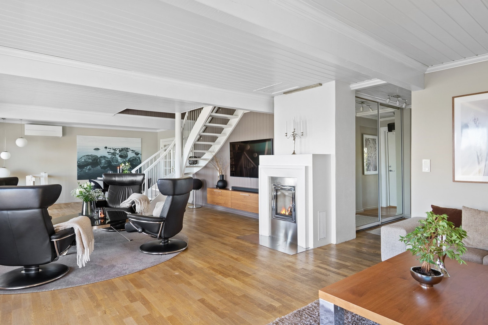 Stuen har varmepumpe fra 2023, samt hygge fra en stilig, innfelt peis med glassdør og ramme i stål. Galleribilde