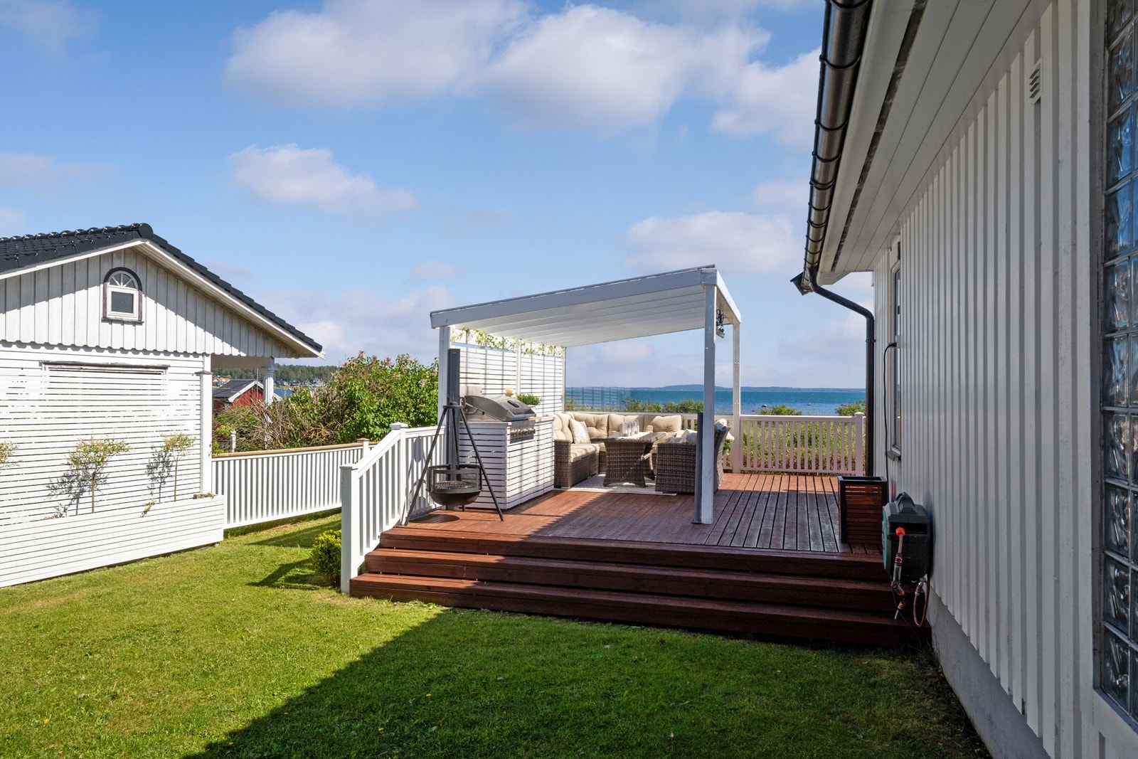 På nordvestsiden av verandaen er det bygd en pergola med tett, transparent tak, stort vindu mot utsikten, varmelamper og et plassbygd utekjøkken med grill i ytterste del. Galleribilde