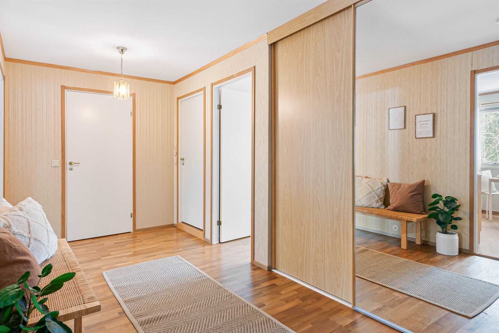 Romslig og innbydende entré og gang med integrert skyvedørsgarderobe Galleribilde