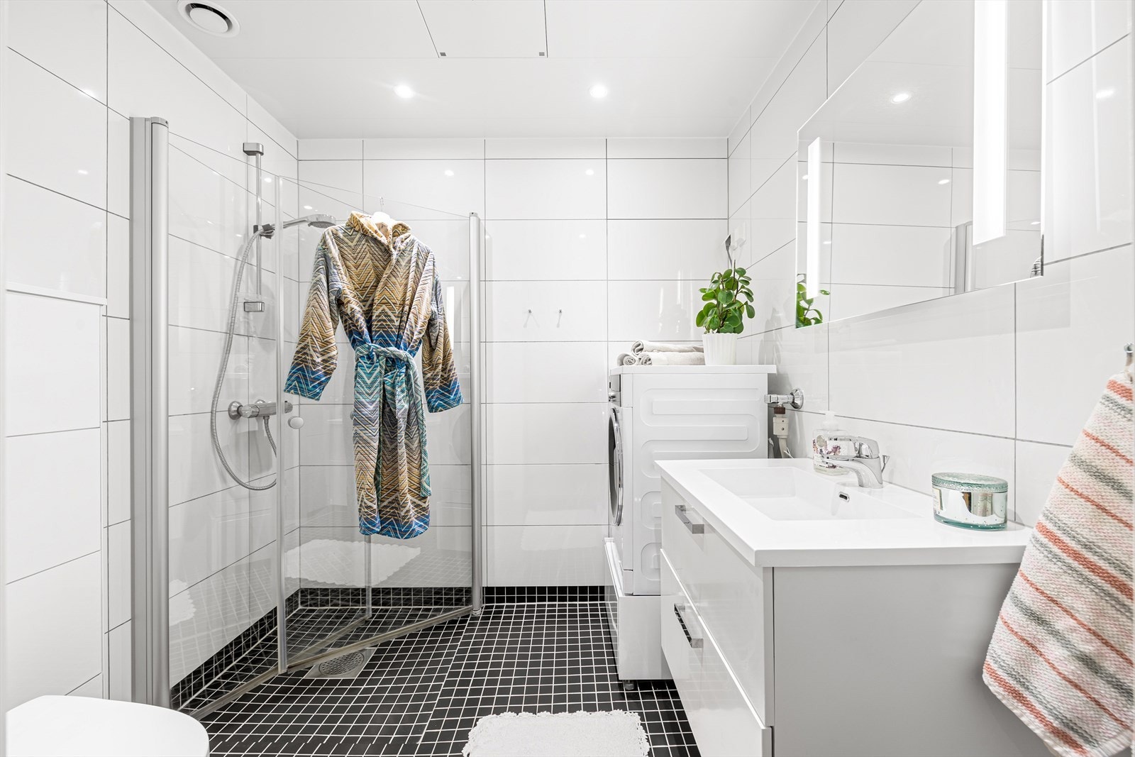 Det 4 m² store badet fremstår som innbydende med helflisede overflater, behagelig gulvvarme og downlights i tak. Galleribilde