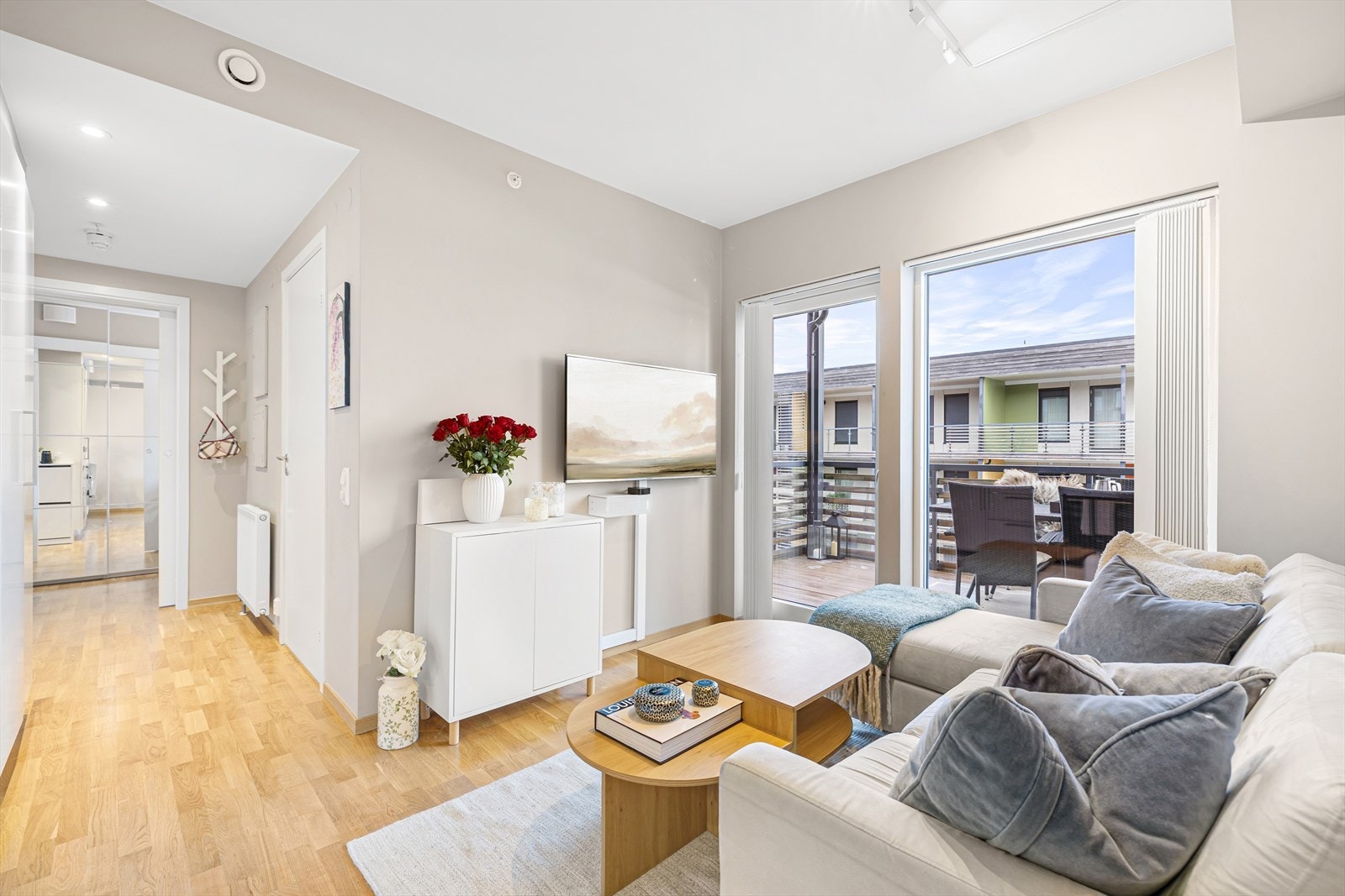 Boligens samlingspunkt inkluderer stue og kjøkken i en åpen løsning på 14,5 m². Allrommet får inn godt med naturlig dagslys fra de store vindusflatene som strekker seg helt fra gulvet og opp mot tak, noe som er med på å gjøre boligen lys og trivelig. Galleribilde