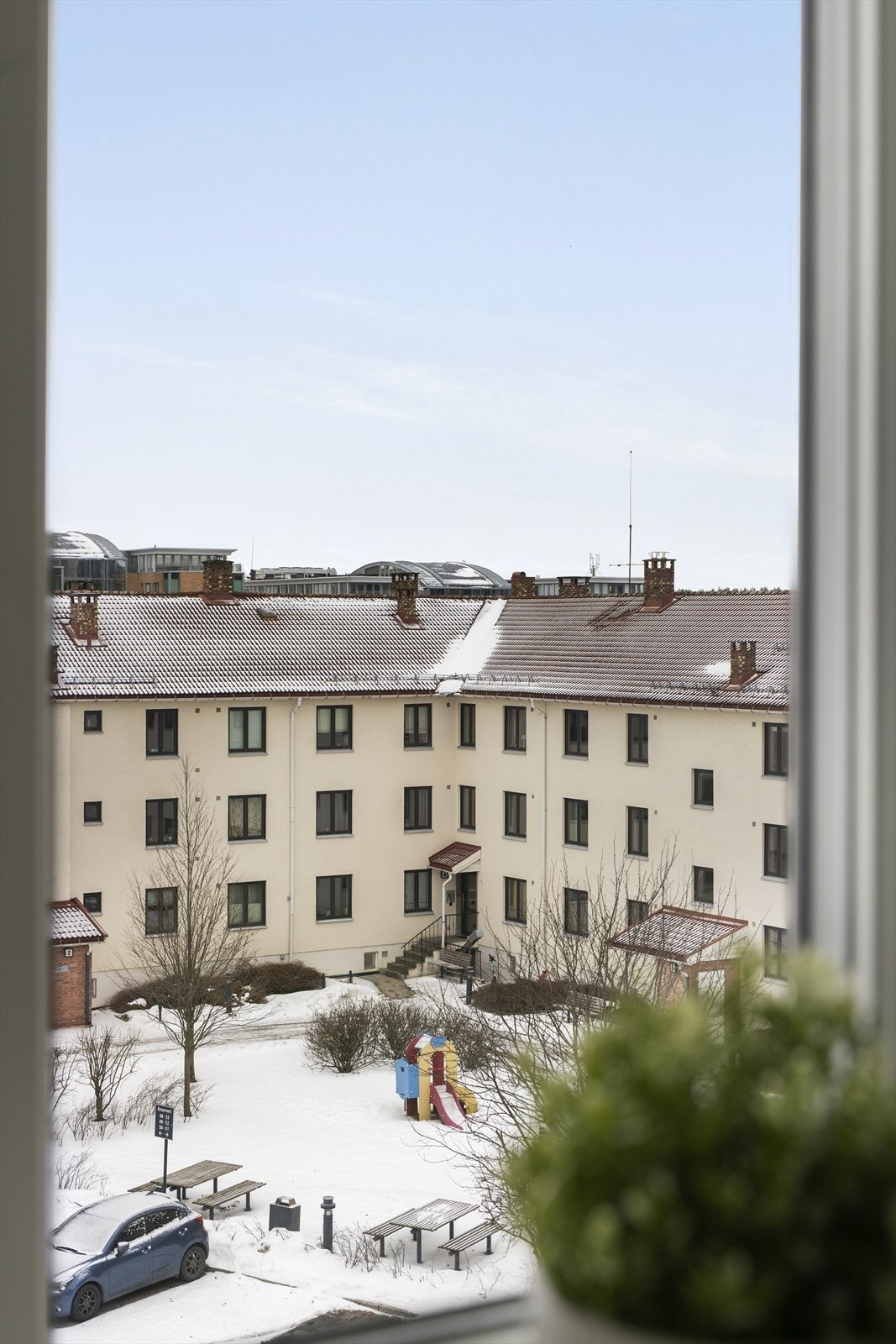 Utsyn mot gårdsrom med sitteplasser og lekestativ. Galleribilde