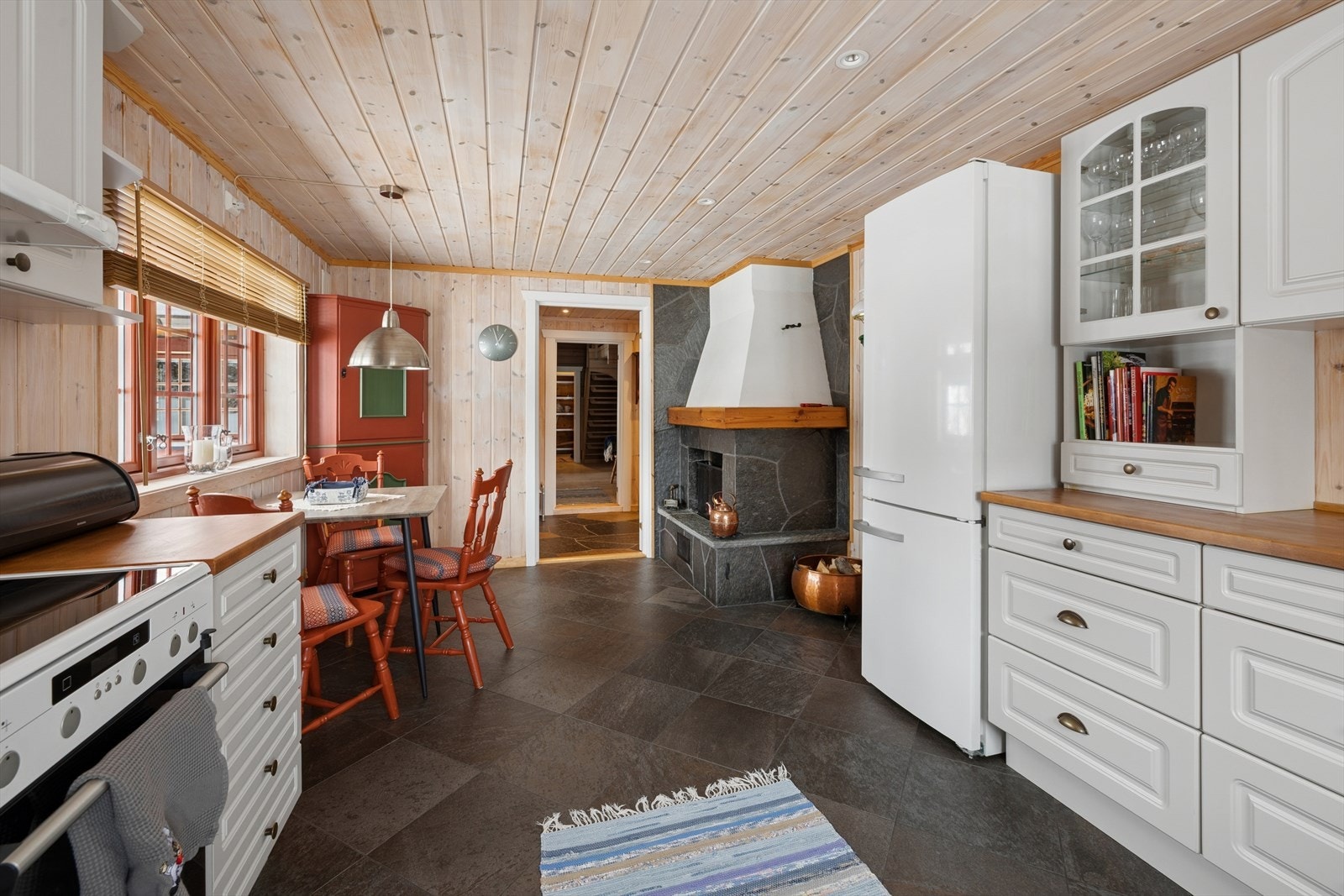 Steinfliser på gulvet med varmekabler, samt panelte vegger og tak. Galleribilde