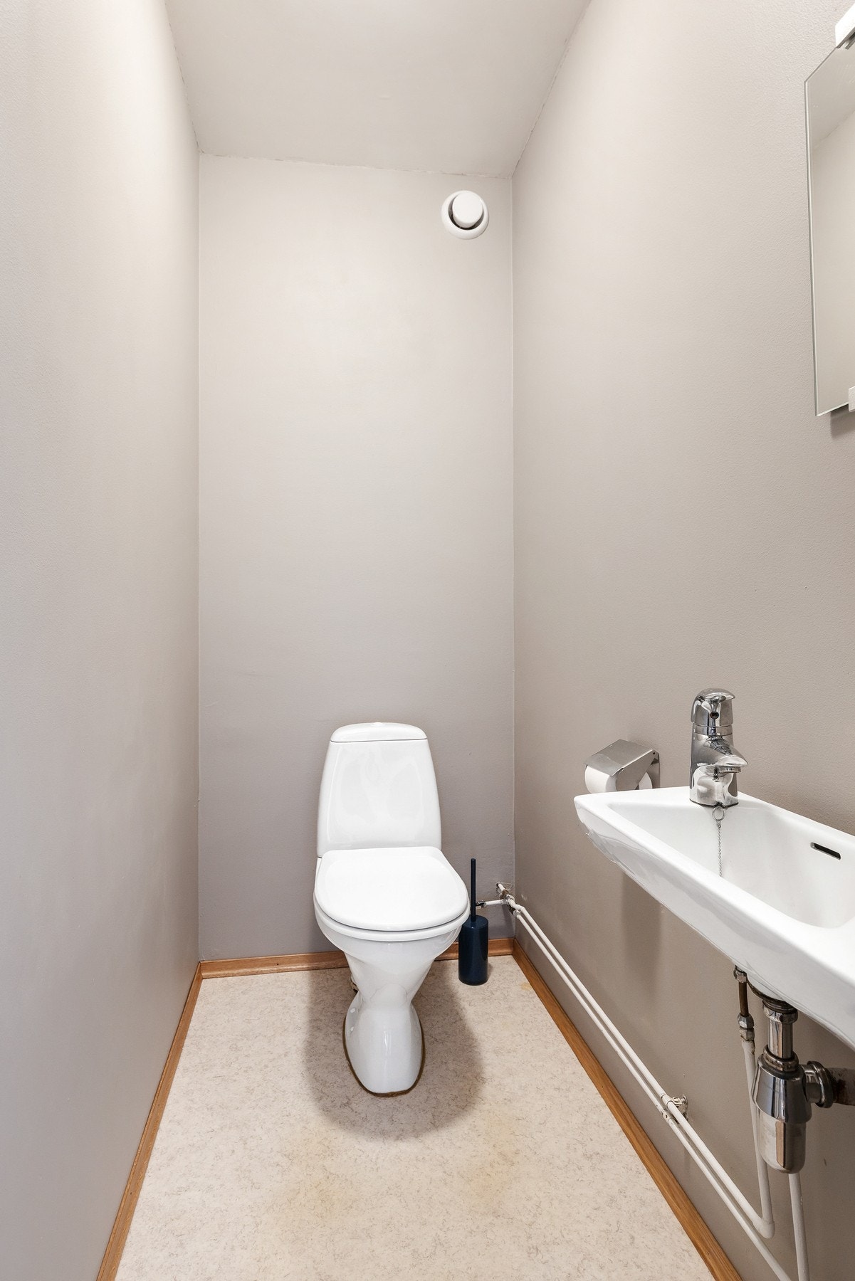 Separat toalettrom med gulvstående klosett og servant Galleribilde