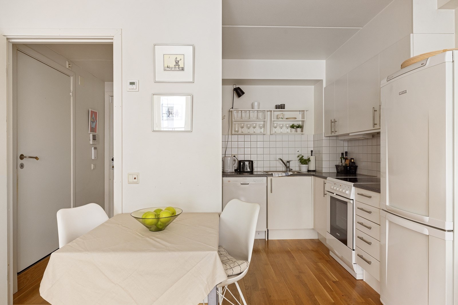 Kjøkkeninnredning med hvite fronter og laminat benkeplate. Galleribilde