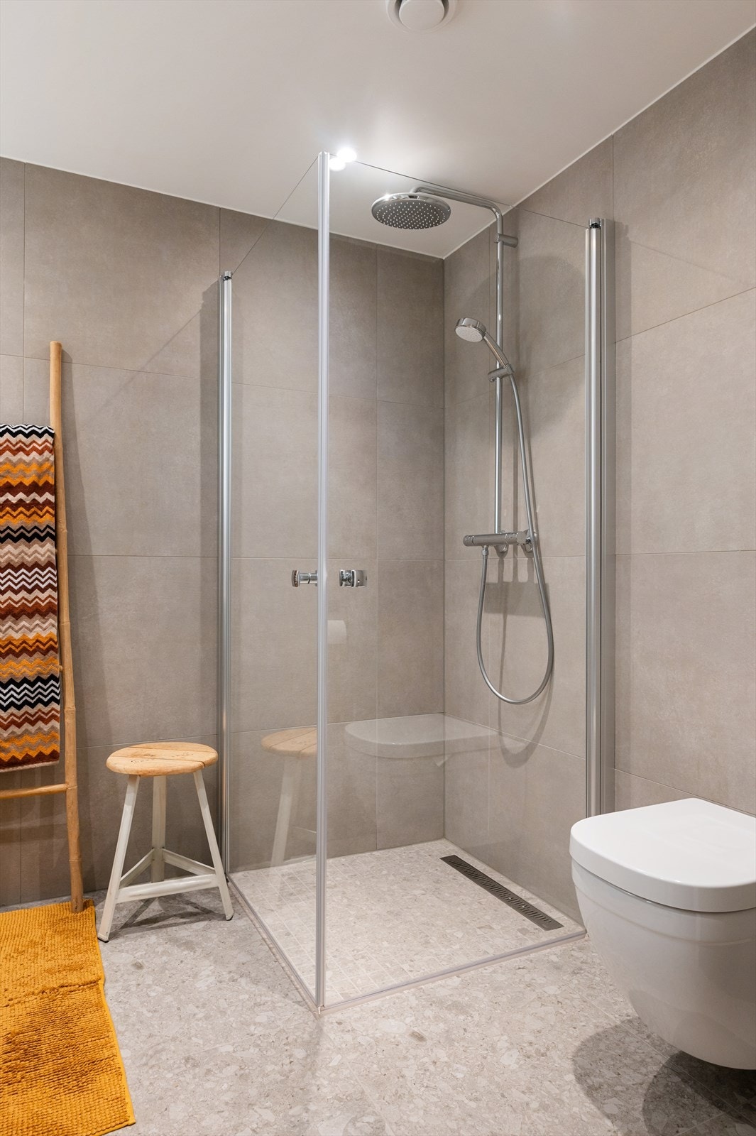 Videre er badet innredet med baderomsinnredning med skuffer, vegghengt speil og vegghengt toalett. Galleribilde