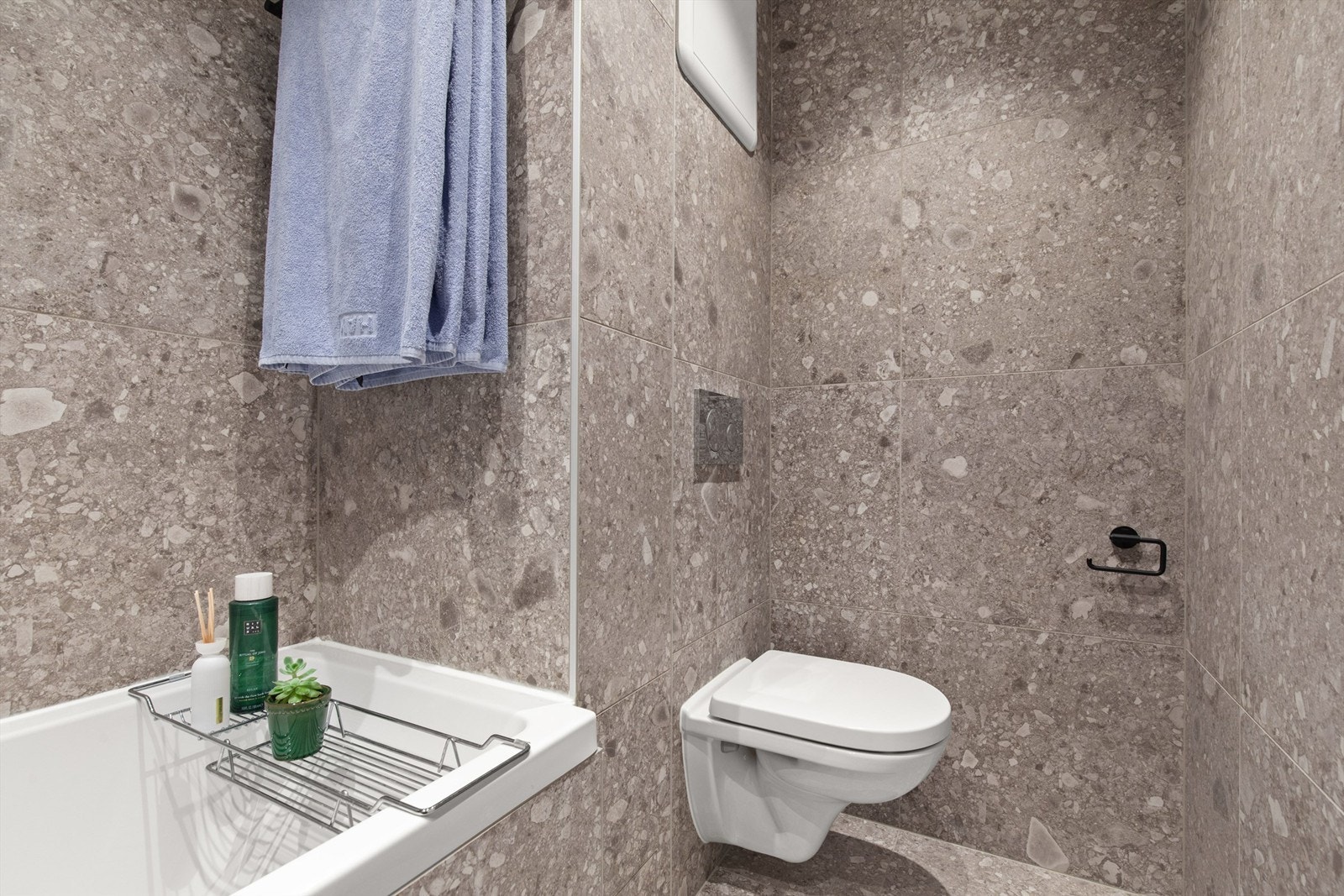 Rommet har elektrisk gulvvarme og innfelte downlights i taket. Innredningen består av et vegghengt klosett, badekar med glassvegg, servant nedfelt i baderomsinnredning og et speilskap. Galleribilde