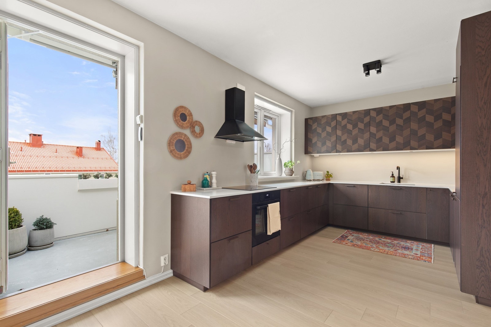 Kjøkkenet er for mange den viktigste sonen i boligen, og er holdt i en åpen løsning mot stuen. Innredningen er av glatte fronter og benkeplate i stein med nedfelt vaskekum. Galleribilde