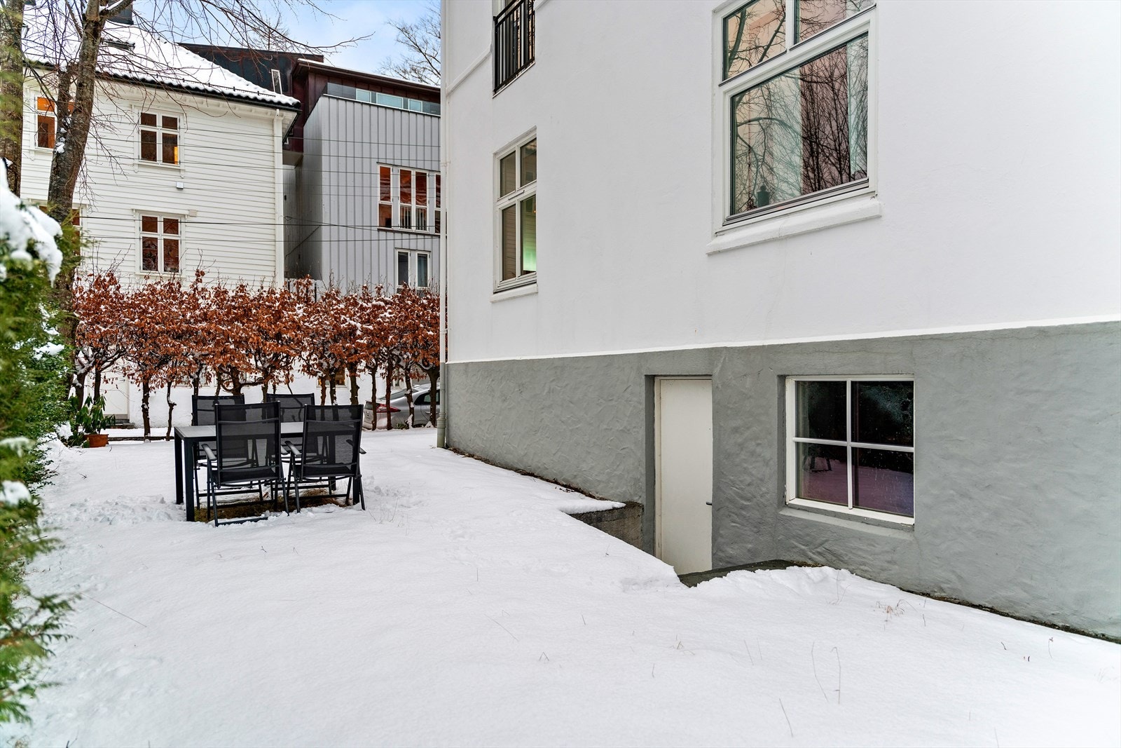 På byggets venstre side er det et hageareal, fordelt på sameie. Her kan du disponere felles utemøbler Galleribilde