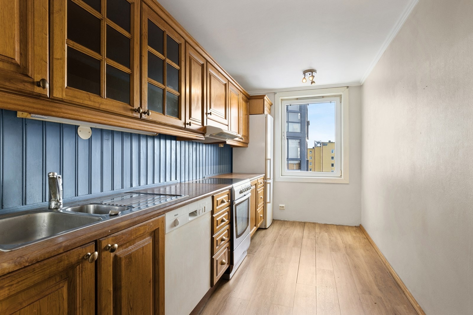 Eldre kjøkkeninnredning med heltre fronter og laminert benkeplate. Galleribilde