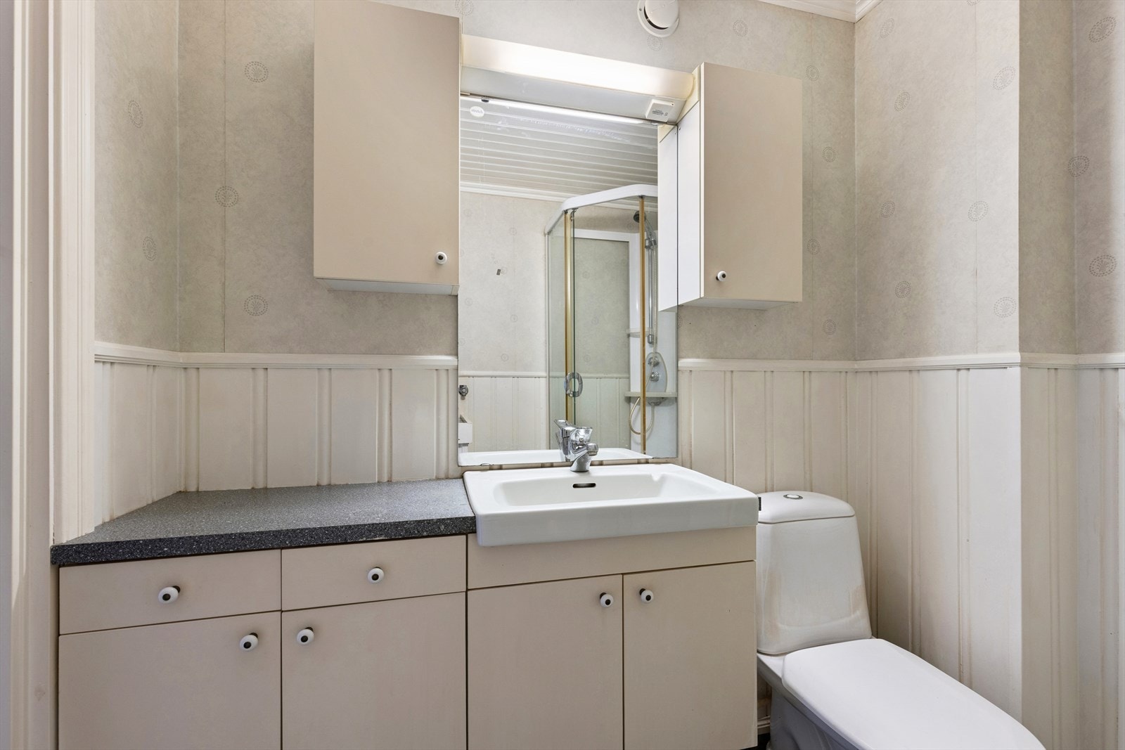 Eldre bad med servant, dusjkabinett og gulvstående toalett. Galleribilde