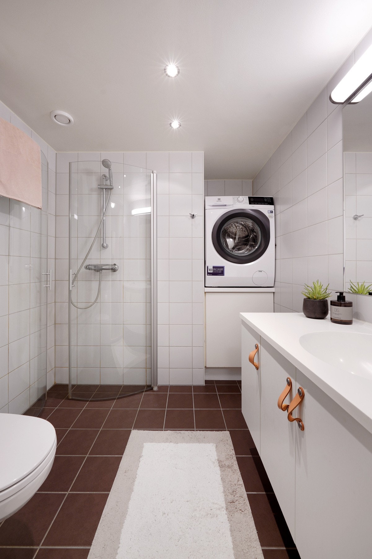 Badet er helflilset med varme i gulv og opplegg for vaskemaskin i arbeidshøyde Galleribilde