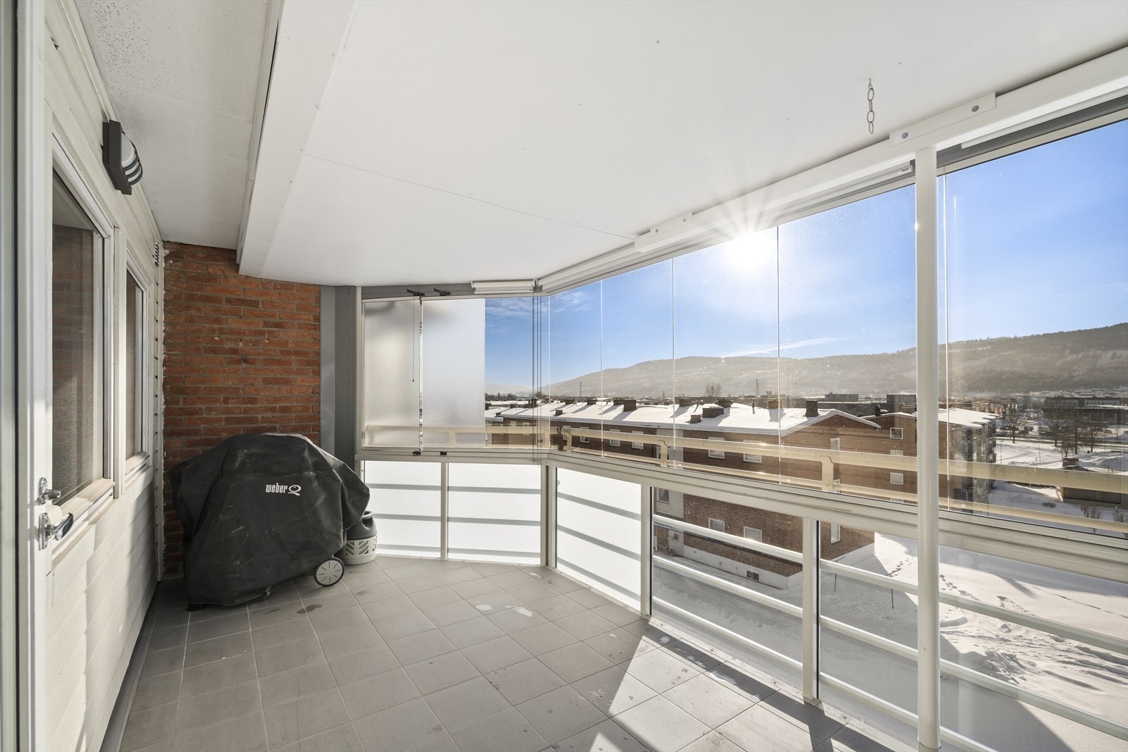 Stor og solrik balkong med fliser på gulv. Galleribilde