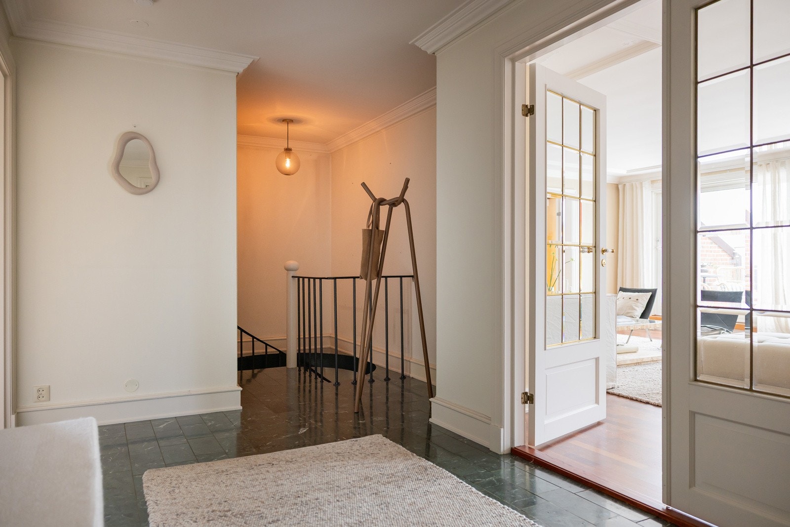 Hallen er innbydende og romslig med grønnmarmorerte gulvfliser som gir et staselig inntrykk, herfra går det vindeltrapp ned til underetasjen. Galleribilde