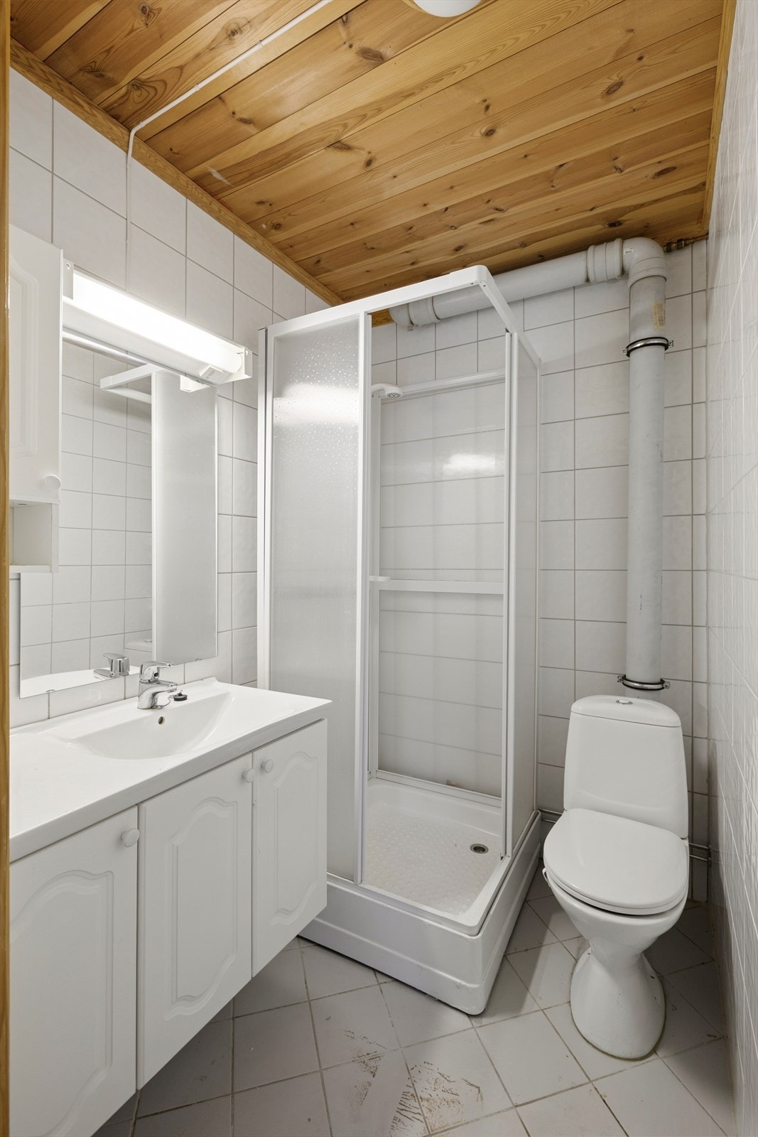 Badet har flislagt gulv med gulvvarme, fliser på veggene og panel i himlingen. Det bemerkes at dette badet ikke har ventilasjon. Galleribilde