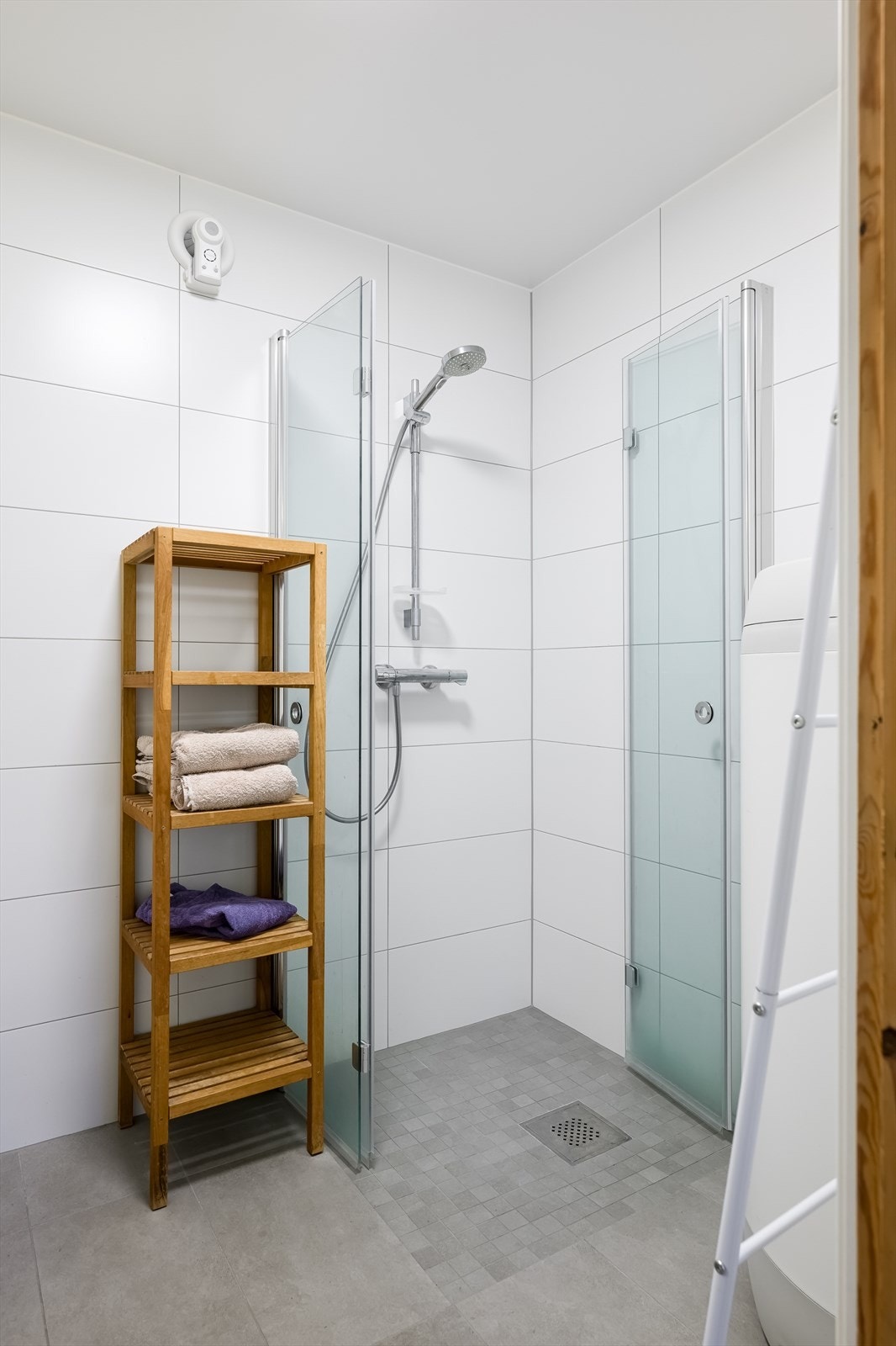 Badet er det varmekabler, vegghengt toalett og et dusjhjørne med innfellbare dører i klart glass Galleribilde