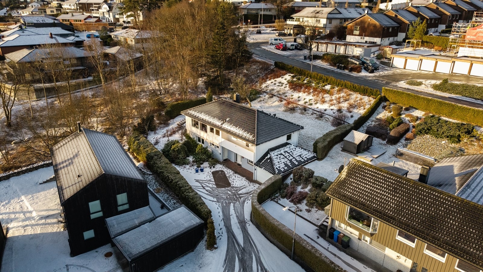 Tomten går over flere nivåer, opparbeidet med trær, busker, hekker, gressplen og diverse beplantning Galleribilde