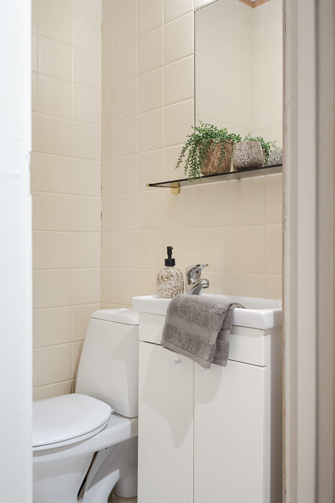 Fra vindfanget er det adkomst til et praktisk gjestetoalett med fliser på gulv og vegger. Toalettrommet er utstyrt med servantskap med hylle og speil over, samt gulvstående toalett. Galleribilde