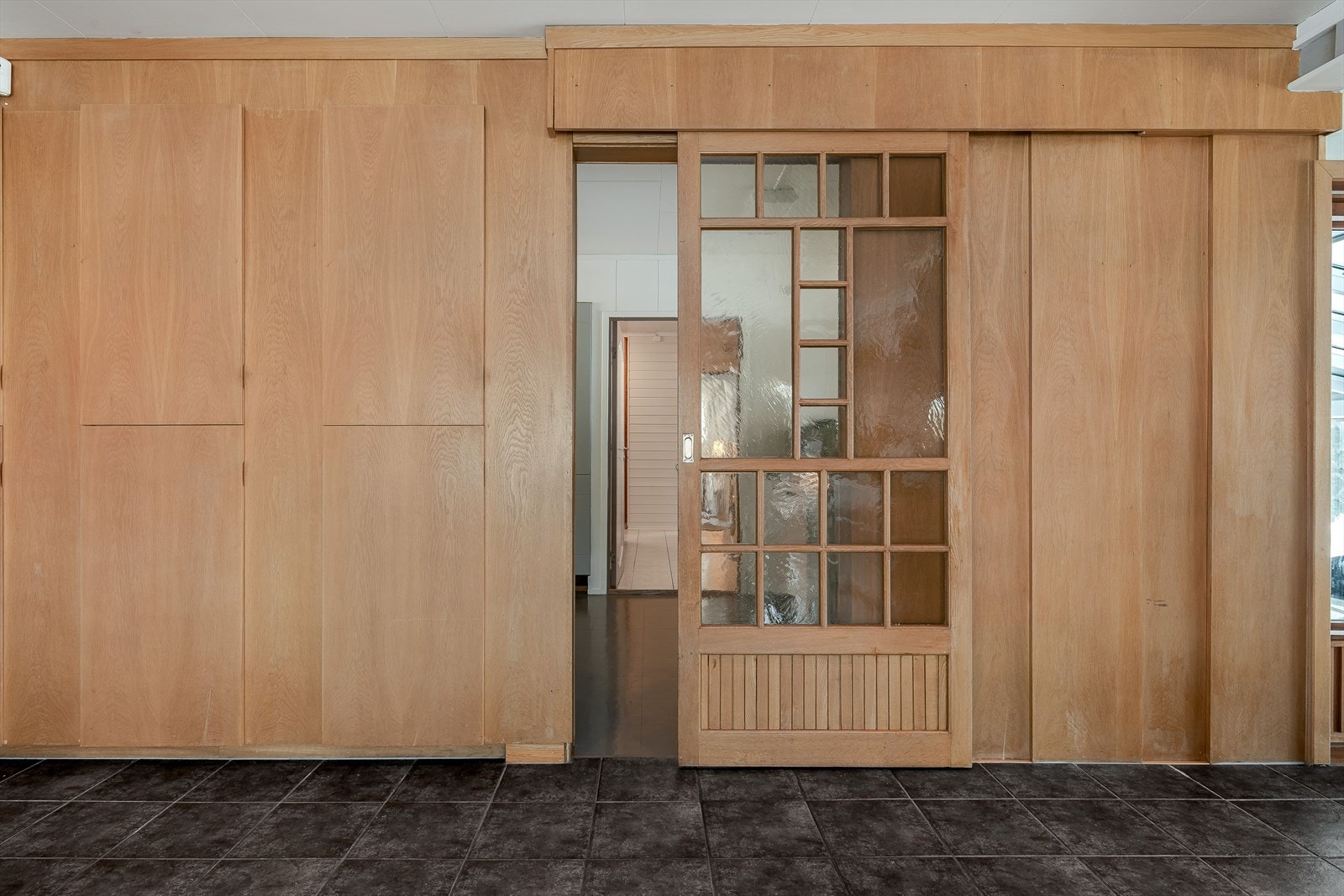 Mellom spisestuen og kjøkkenet er det flotte plassbygde skap og en nydelig skyvedør i solid treverk med glassfelt. Galleribilde