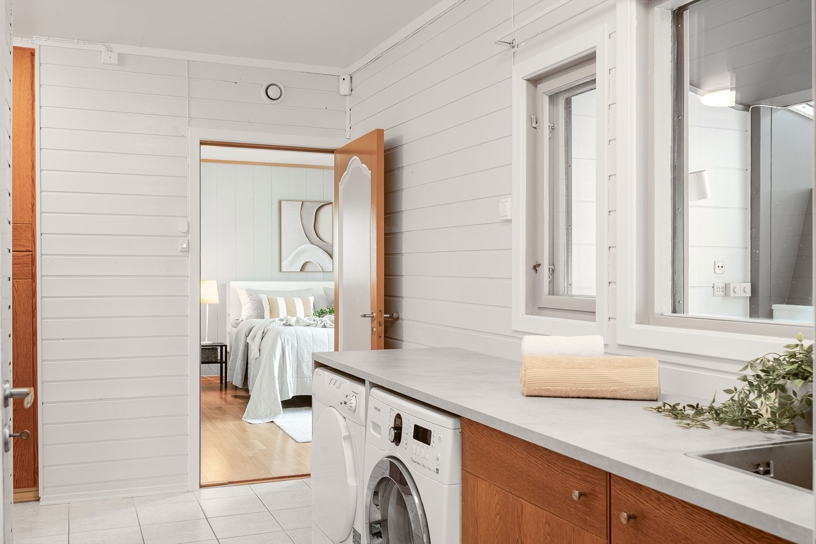 Vaskerommet har flott innredning som består av skap og laminert benkeplate med nedfelt utslagskum. Praktisk med plass og opplegg for både vaskemaskin og tørketrommel under benkeplaten. Galleribilde