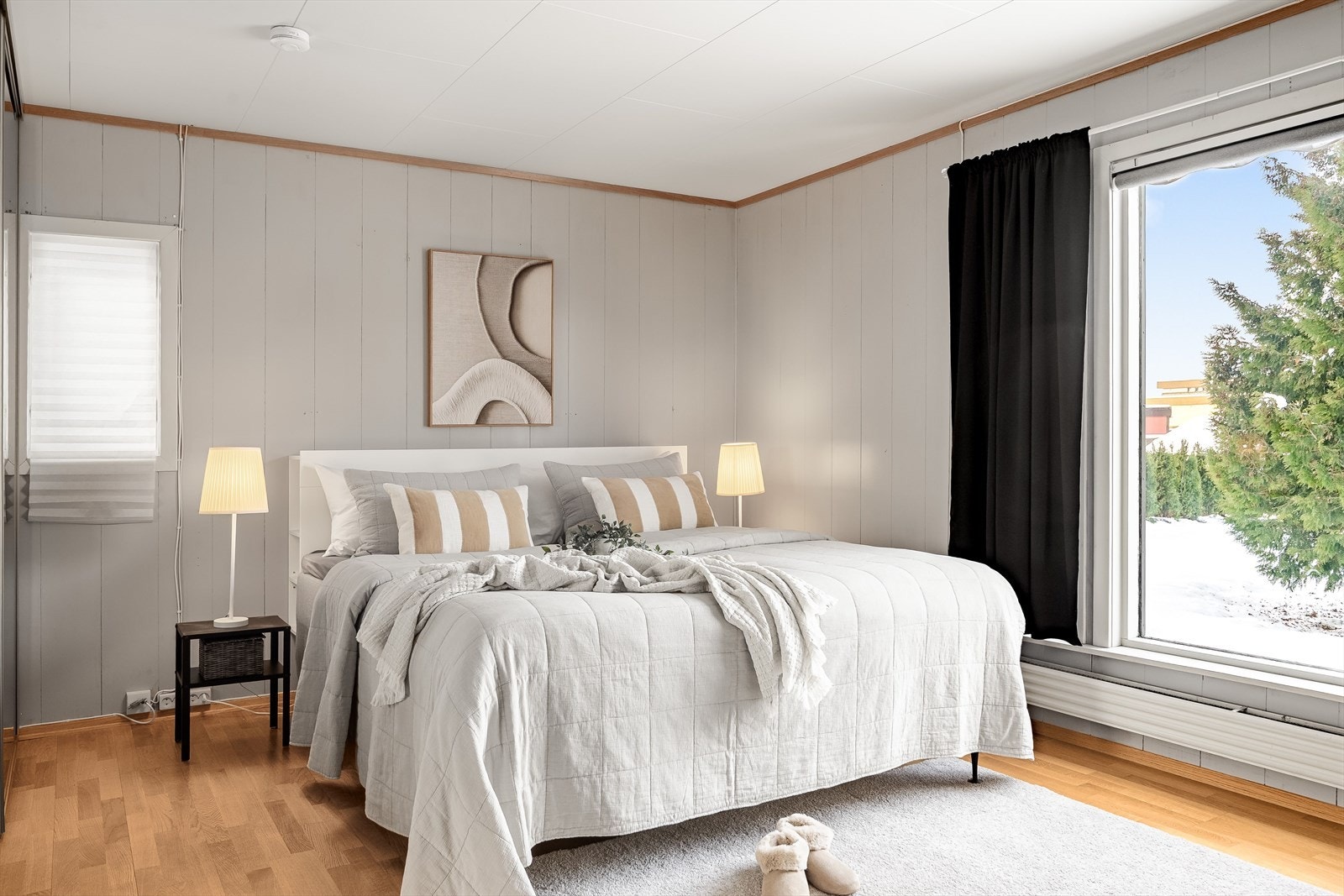 Boligen har et stort, lyst og fint hovedsoverom med parkett på gulv og malt panel på veggene. Galleribilde