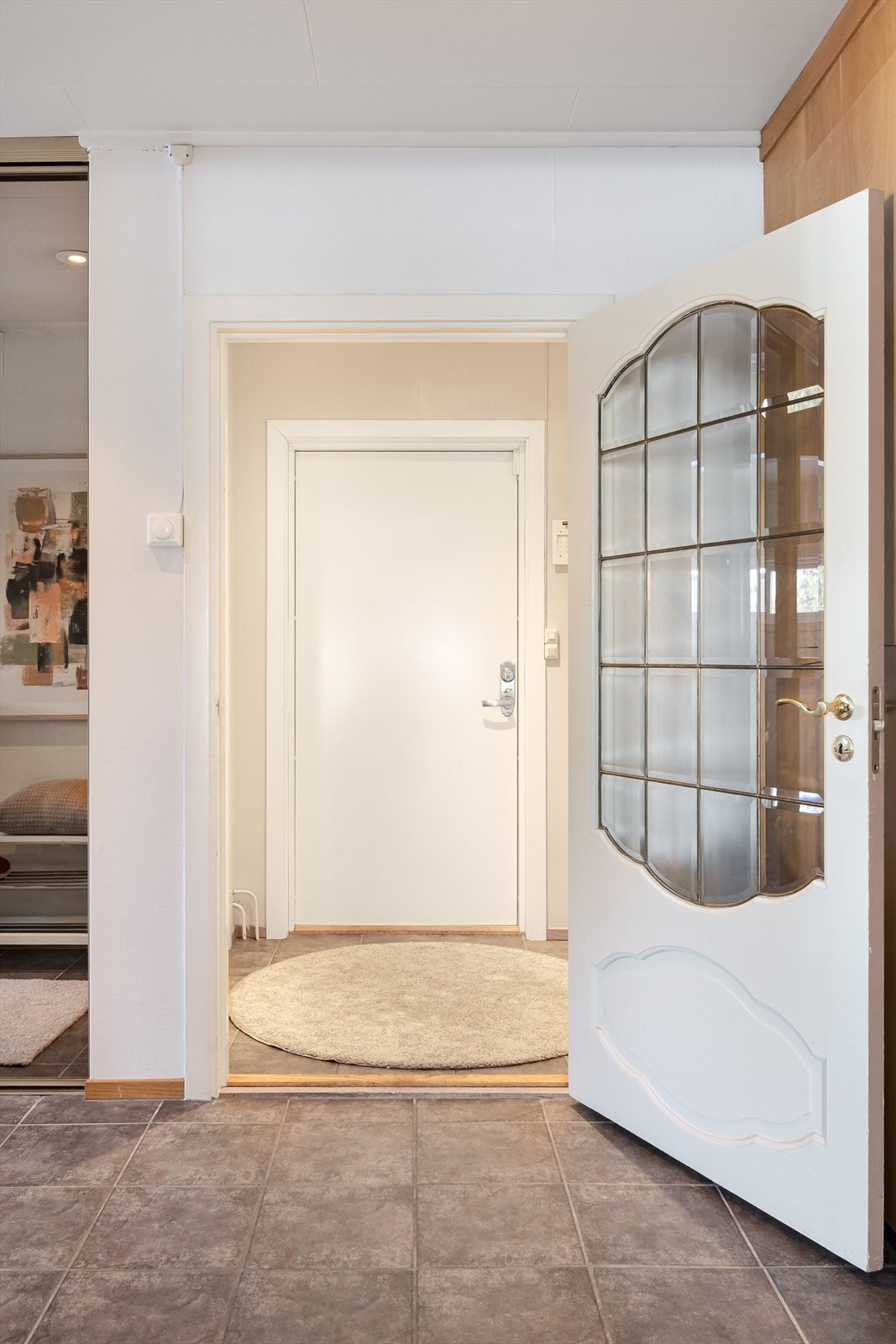 Når du entrer boligen, kommer du inn i et lyst og praktisk vindfang med flislagt gulv. Galleribilde