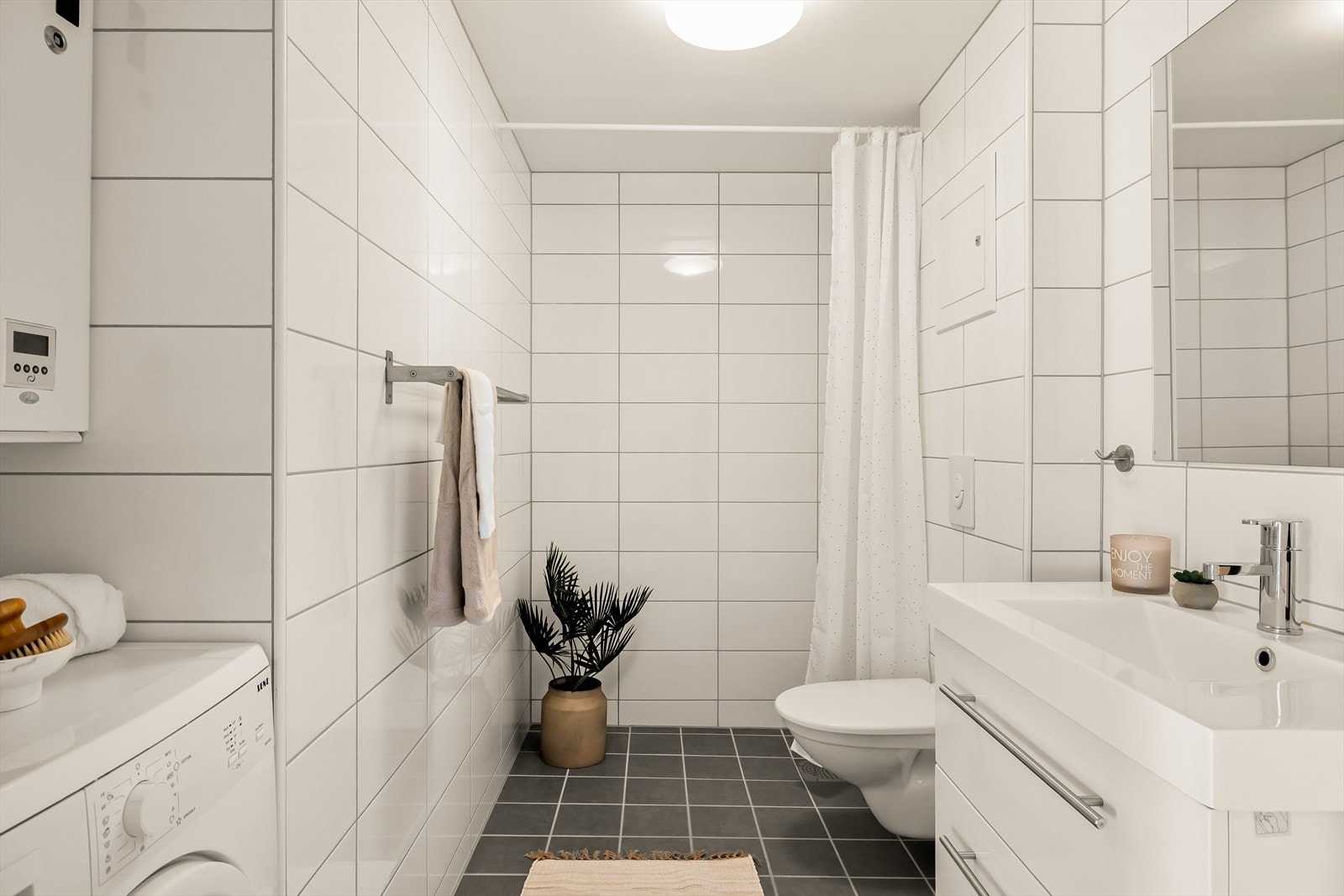 Badet fremstår flott og tidløst med rene linjer og lyse, moderne overflater. Veggene er helfliset i klassiske, hvite fliser som gir et stilrent uttrykk Galleribilde