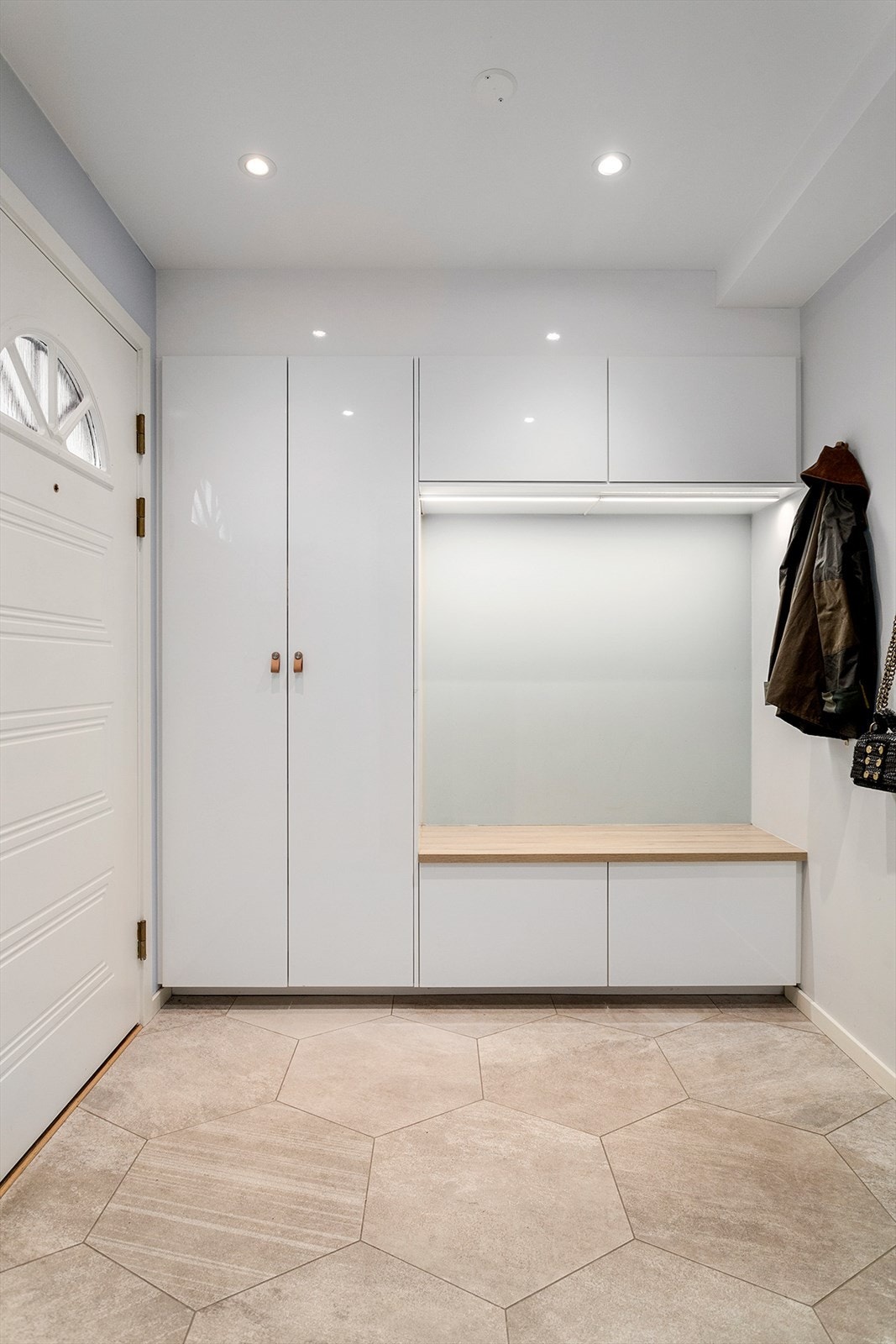 Smart garderobeløsning med benk gir praktisk oppbevaring og en komfortabel plass å sitte. Galleribilde