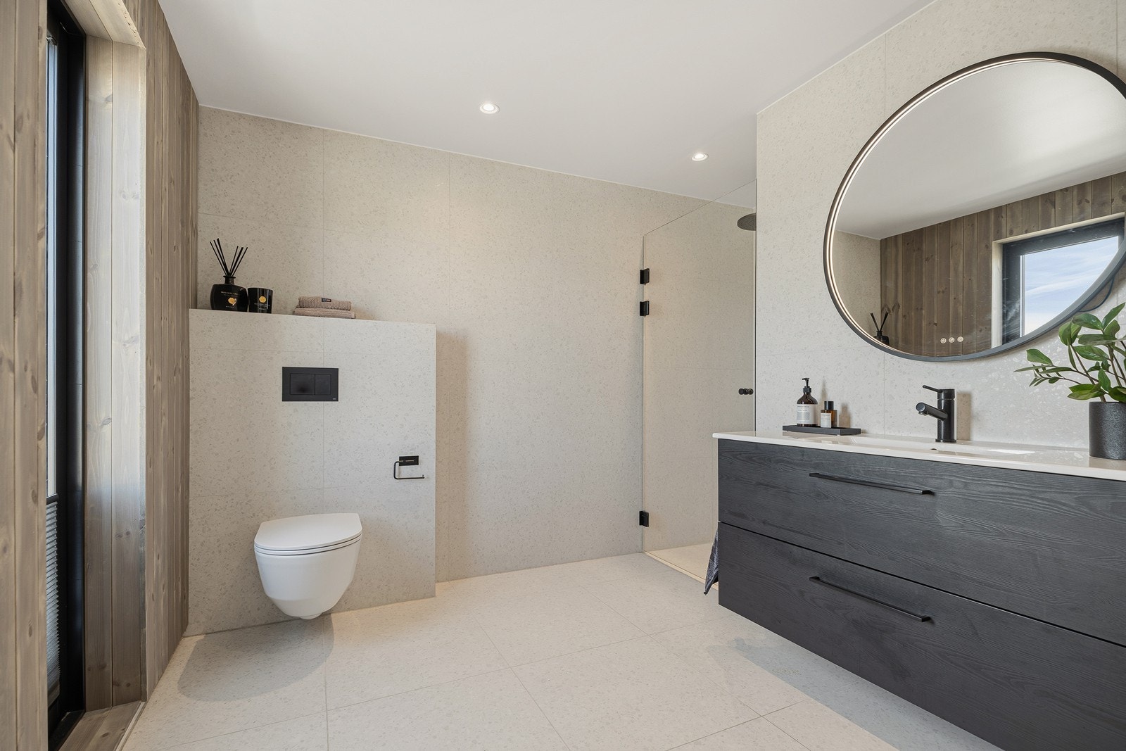 Lekkert baderom bestående av vegghengt toalett, baderomsinnredning og dusjnisje Galleribilde