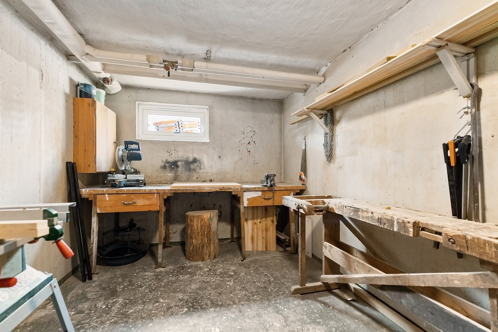 Felles hobbybod i kjeller med god plass til ulike prosjekter og stativ for prepping av ski Galleribilde