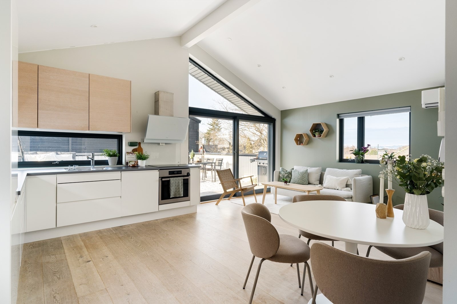 Det er åpen løsning mellom rommene, med god plass til både spisegruppe, sofa og ytterligere møblering. Galleribilde