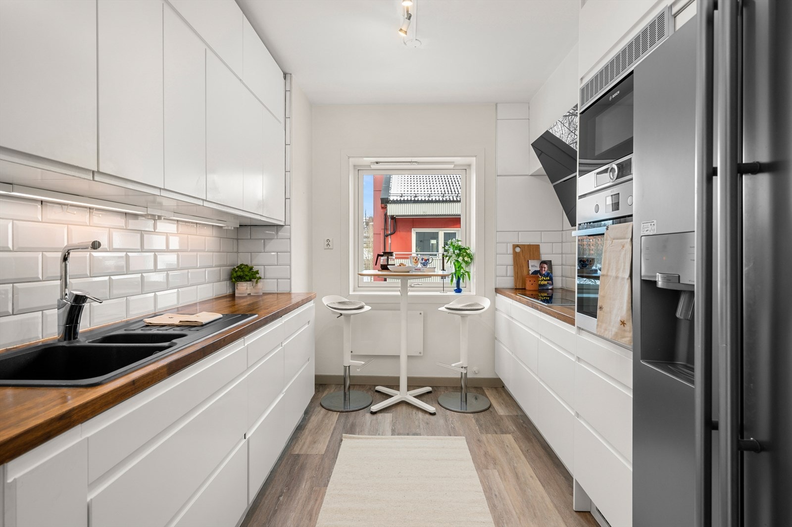 Kjøkkenet er innredet med slette fronter og benkeplate i heltre, som gir et moderne og tidløst uttrykk. Galleribilde