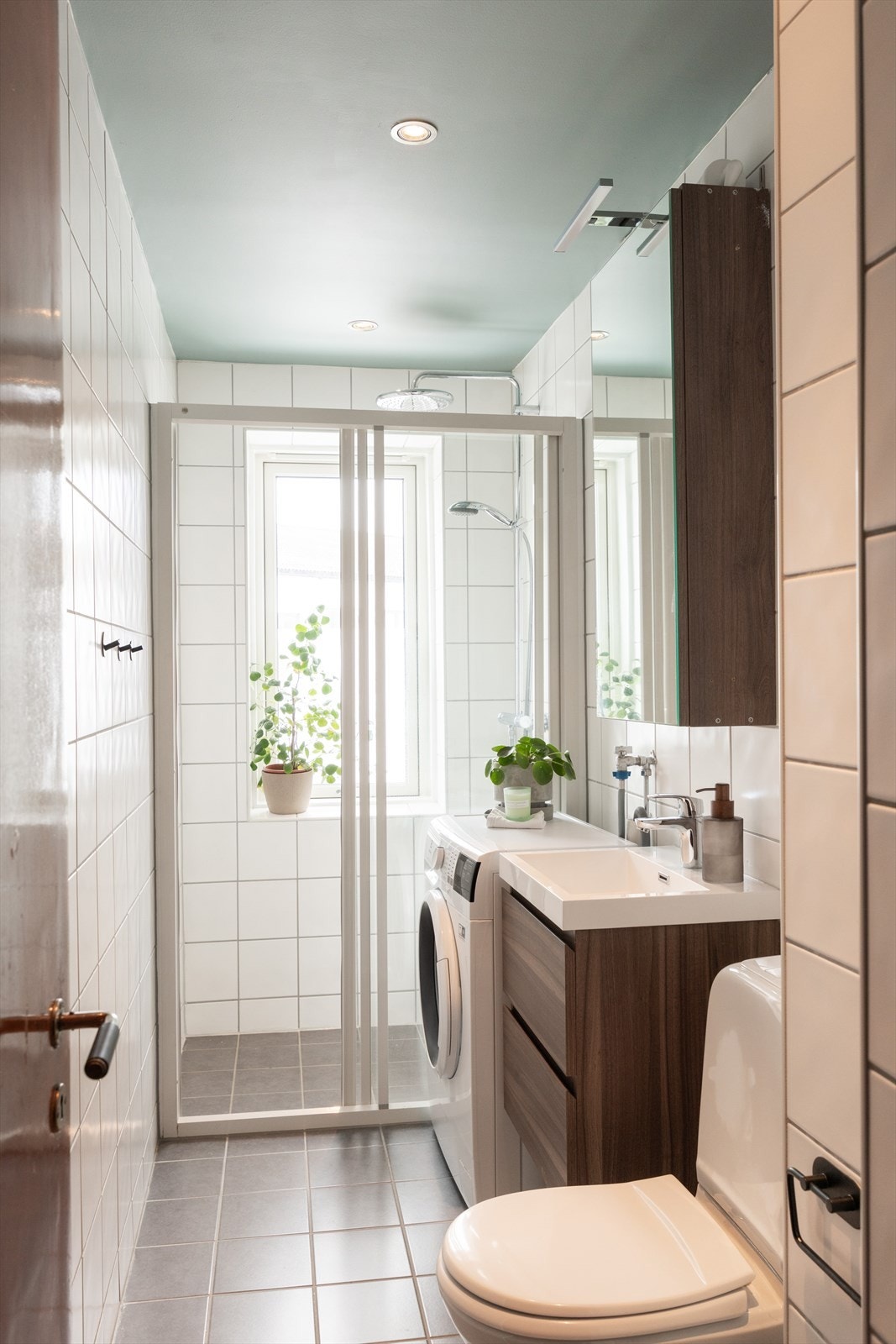 Badet er innredet med klosett, servant nedfelt i innredning og, speil med lys og dusjnisje med kabinettdører og dusjarmatur fra Grohe. Galleribilde